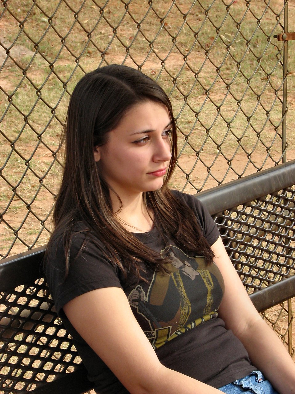 A teenage girl sitting on a bench outside : Free Stock Photo