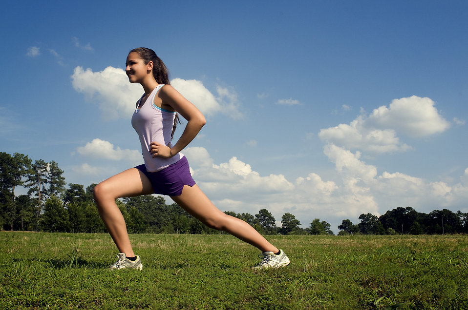 A young woman stretching outdoors before exercising : Free Stock Photo