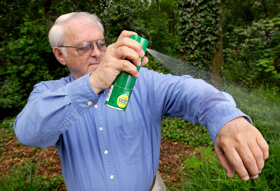 A man spraying insect spray on his shirt : Free Stock Photo