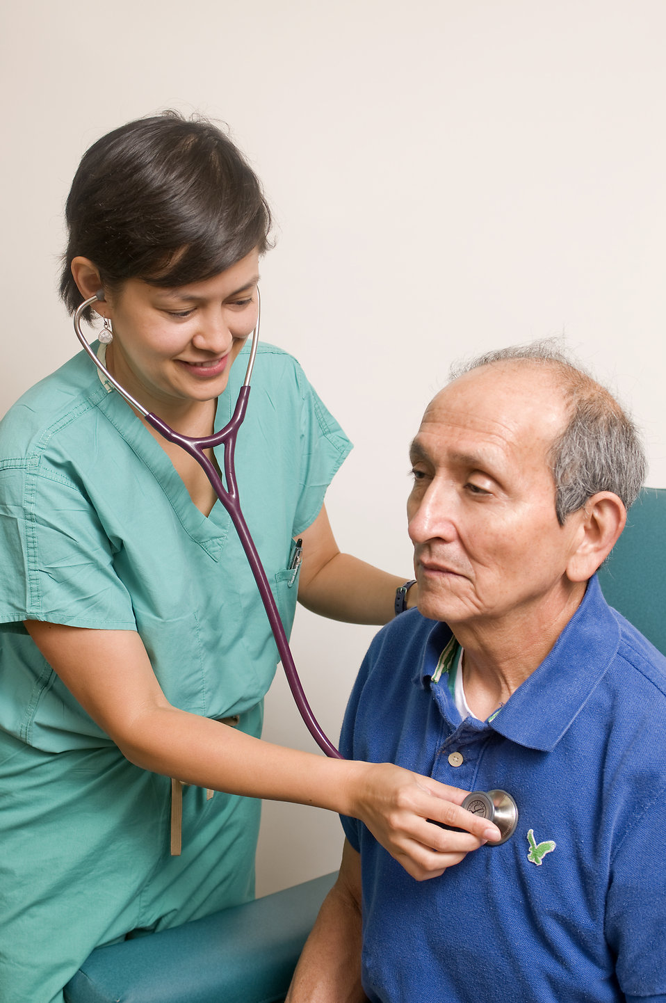 A female doctor examining an elderly male patient : Free Stock Photo