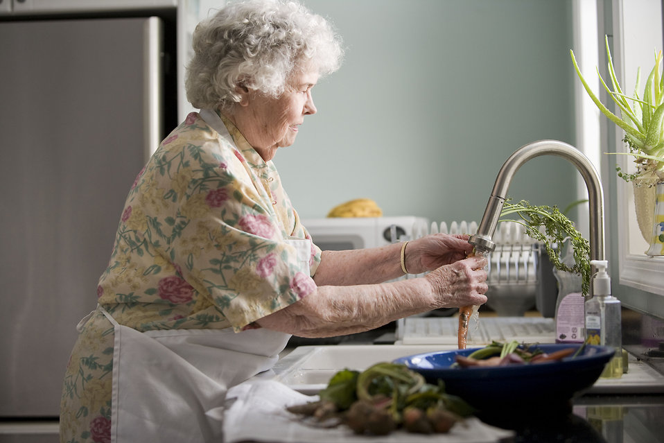 An elderly woman washing produce : Free Stock Photo