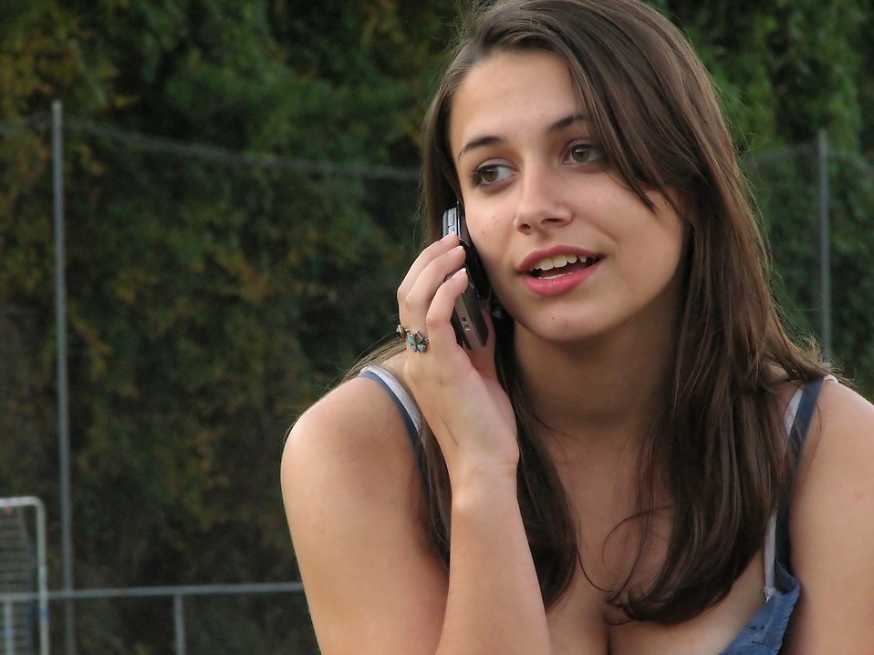 A beautiful teen girl talking on a cell phone outdoors : Free Stock Photo