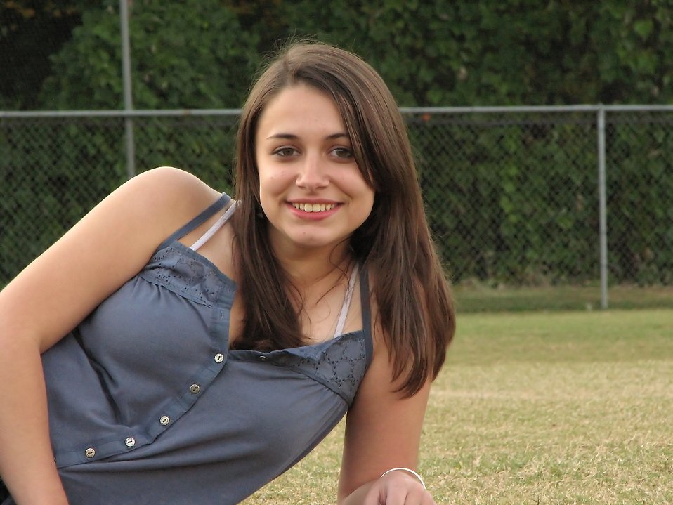 A beautiful teen girl lying in the grass outdoors : Free Stock Photo