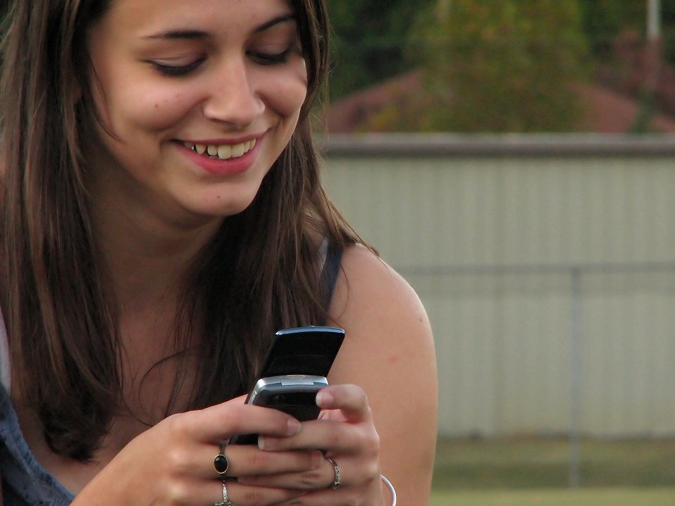 Beautiful teen girl using a cell phone : Free Stock Photo