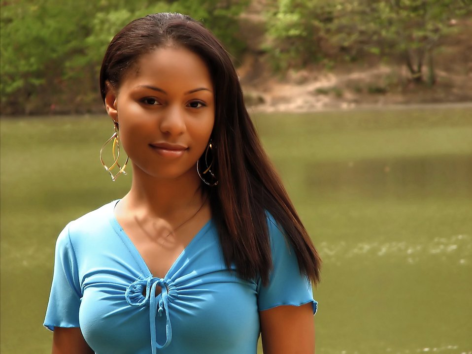 A beautiful African American teen girl posing by a lake : Free Stock Photo