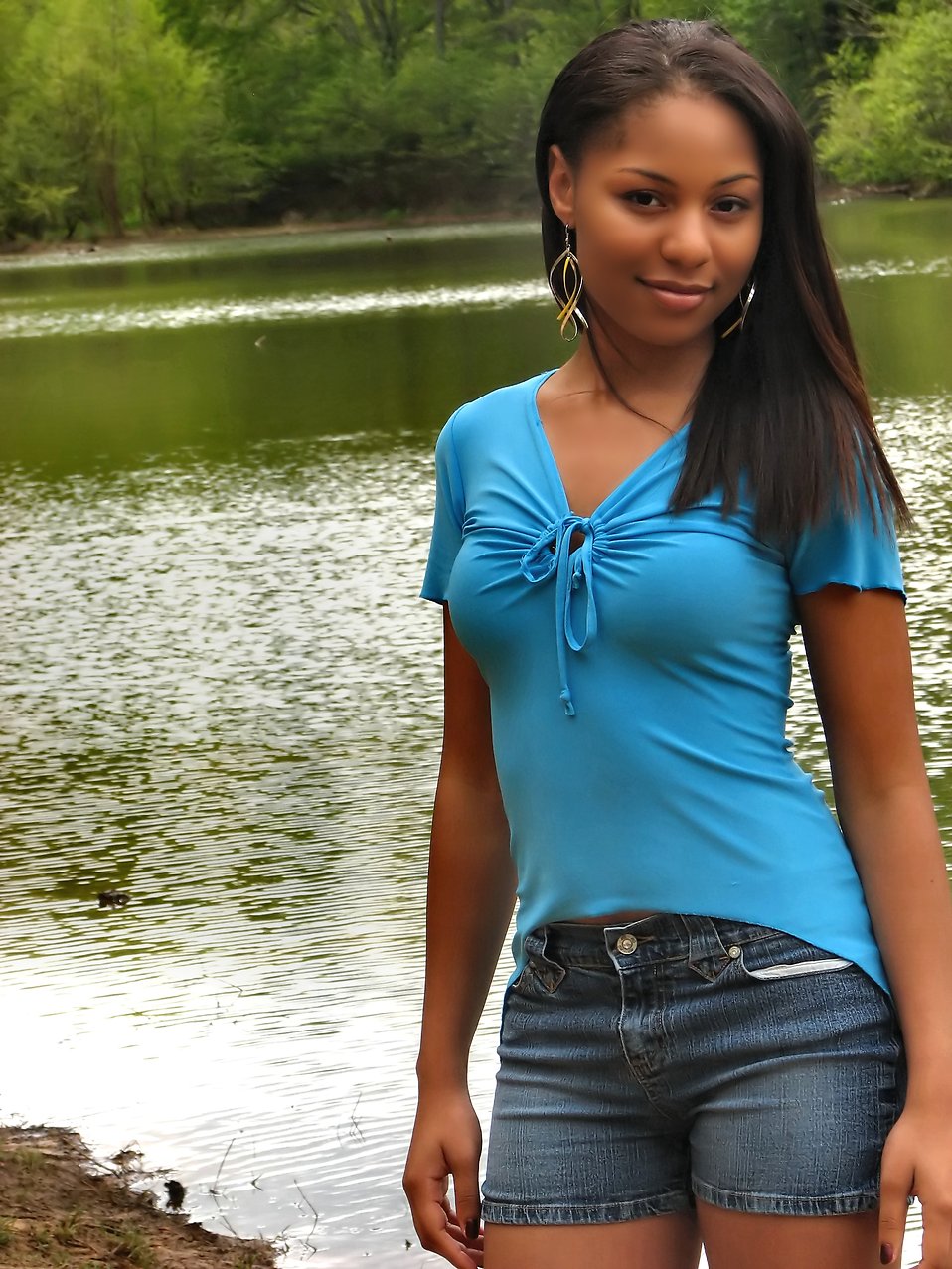 A beautiful African American teen girl posing near a lake : Free Stock Photo