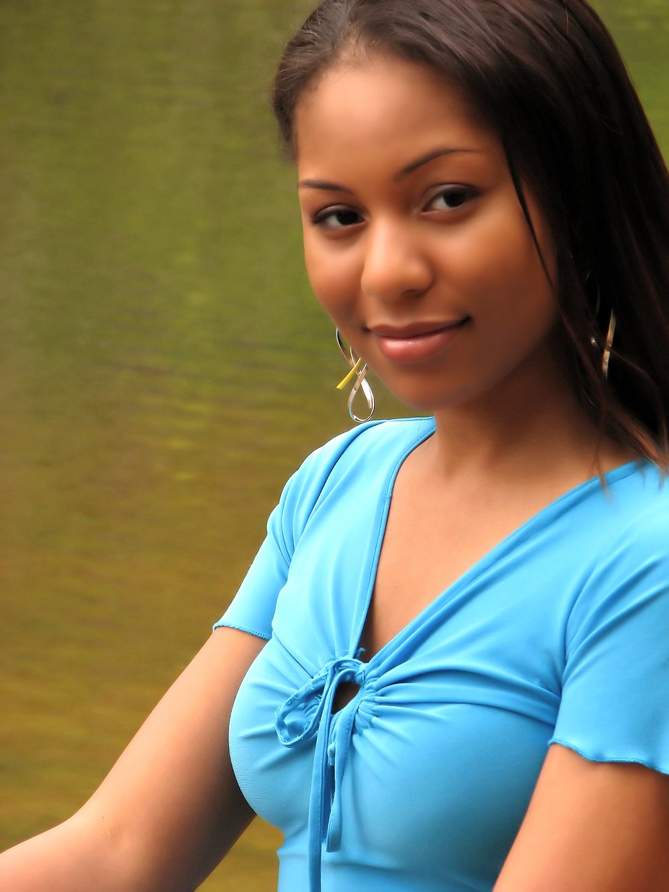 A beautiful African American teen girl posing by a lake : Free Stock Photo