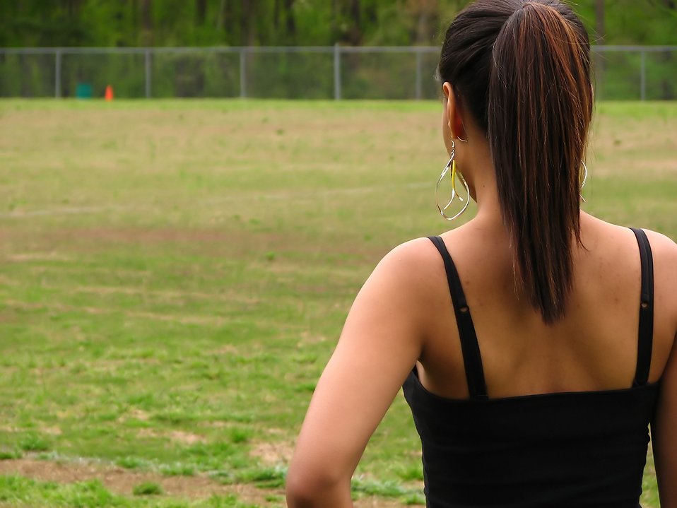 A beautiful teen African American girl looking over an athletic field. : Free Stock Photo