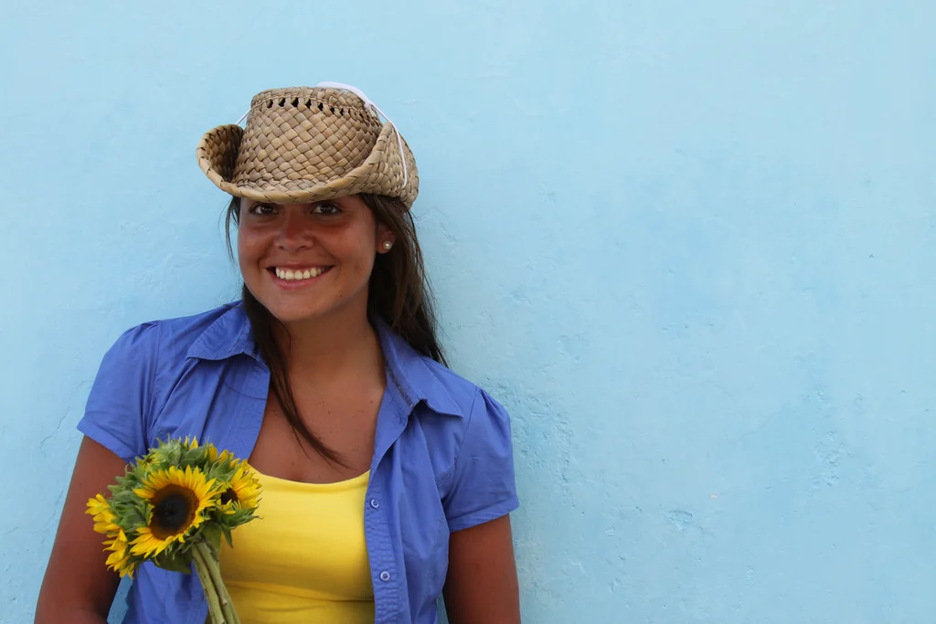 A beautiful woman with a hat holding a sunflower : Free Stock Photo