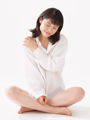 Free Stock Photo: A beautiful woman sitting down with crossed legs isolated on a white background