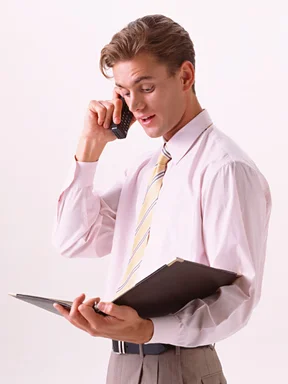 Free Stock Photo: A young business man in a tie talking on a cell phone  isolated on a white background