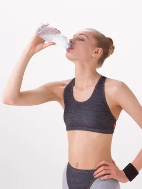 Free Stock Photo: A beautiful blonde drinking a bottle of water isolated on a white background