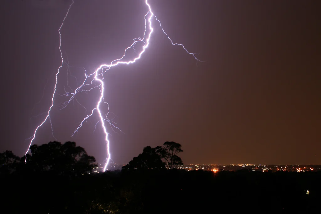 Lightning striking over a city at night : Free Stock Photo
