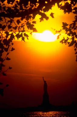 Free Stock Photo: Silhouette of the Statue of Liberty monument on Liberty Island at sunset