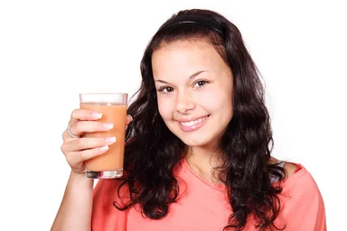 Free Stock Photo: A beautiful woman holding a glass of juice