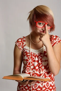 Free Stock Photo: A beautiful smart young girl with glasses reading a book