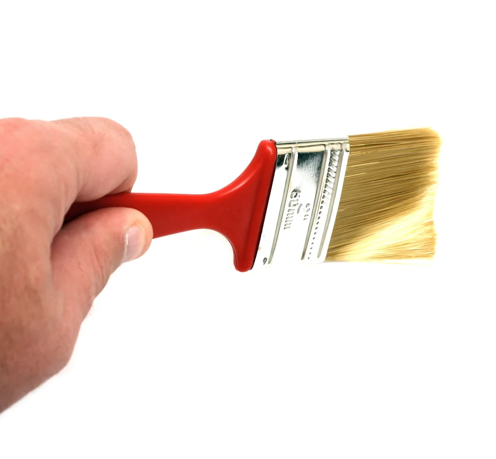 A hand holding a paint brush isolated on a white background : Free Stock Photo