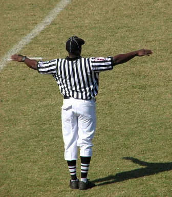 Free Stock Photo: A football referee on a field making an incomplete pass signal