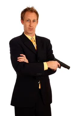 Free Stock Photo: A young businessman in a suit holding a pistol