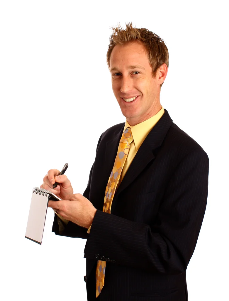 A young businessman in a suit writing on a notepad : Free Stock Photo