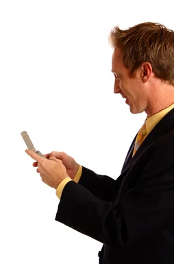 Free Stock Photo: A young businessman in a suit texting on a cell phone