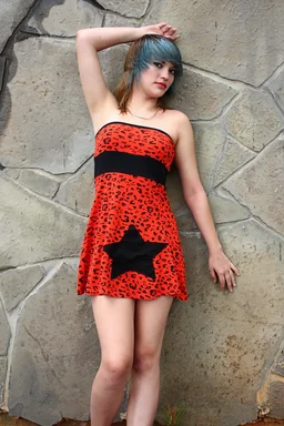 Free Stock Photo: A beautiful young woman posing in a red dress against a stone wall