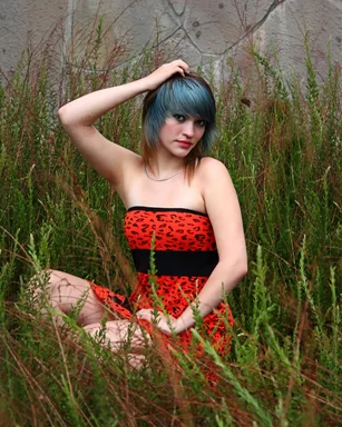 Free Stock Photo: A beautiful young woman posing in a red dress in tall grass