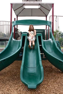 Free Stock Photo: A beautiful young girl playing on a playground with a dog