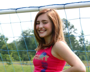 Free Stock Photo: A cute young girl posing by a soccer goal