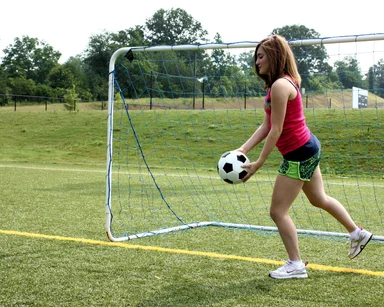 Free Stock Photo: A cute young girl kicking a soccer ball