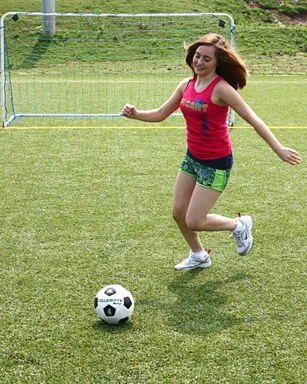 Free Stock Photo: A cute young girl kicking a soccer ball