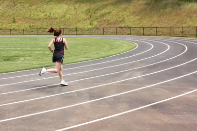 Free Stock Photo: A cute young girl running on a track field