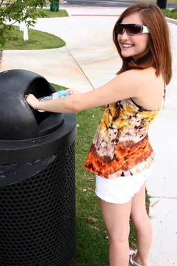Free Stock Photo: A young girl throwing away trash in a trash can