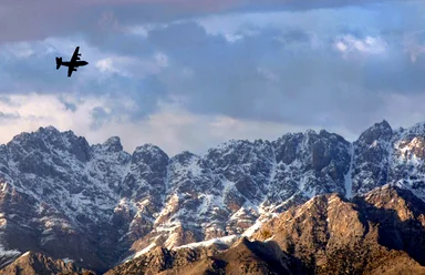 Free Stock Photo: A military airplane flying over mountains