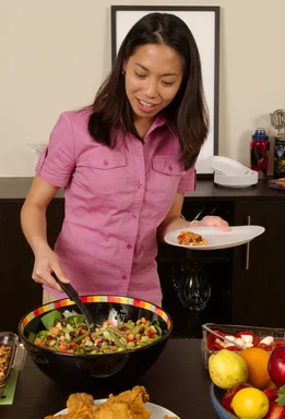 Free Stock Photo: A young Asian woman serving herself food from a table