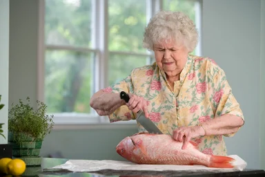 Free Stock Photo: An elderly woman preparing fresh fish