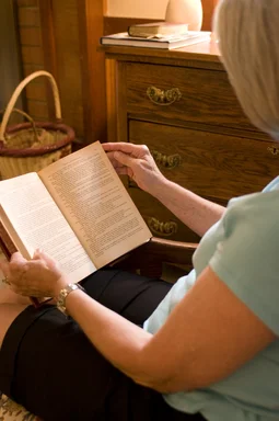Free Stock Photo: A woman reading a book in her home