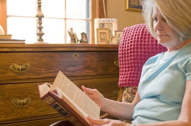 Free Stock Photo: A woman reading a book in her home