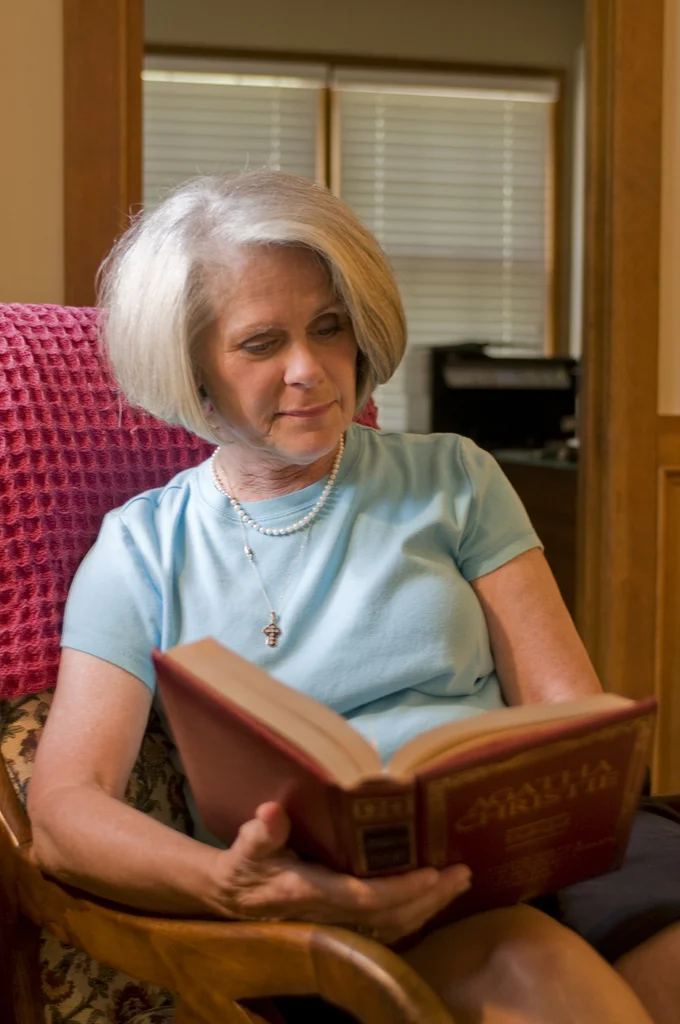 A woman reading a book in her home : Free Stock Photo
