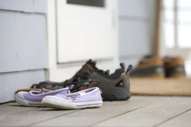 Free Stock Photo: Pairs of shoes on a door mat