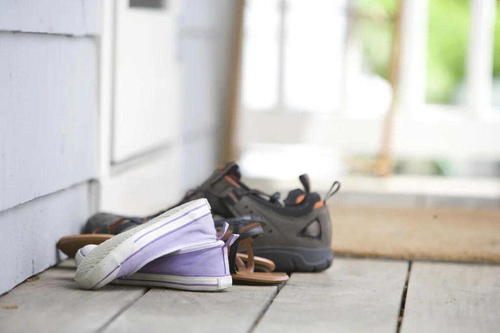 Pairs of shoes on a door mat : Free Stock Photo