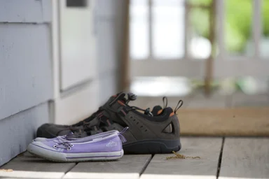 Free Stock Photo: Pairs of shoes on a door mat