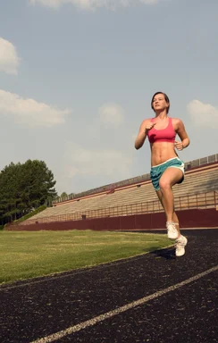 Free Stock Photo: A healthy young woman running outdoors on a track