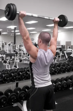 Free Stock Photo: A healthy young man lifting weights in a gym