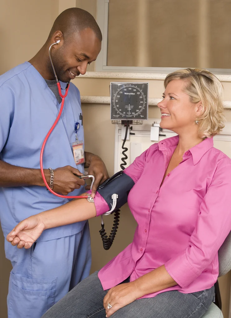A male nurse taking a woman's blood pressure : Free Stock Photo