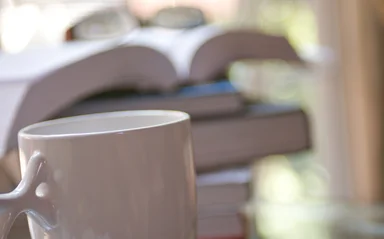 Free Stock Photo: A cup of coffee with a stack of books