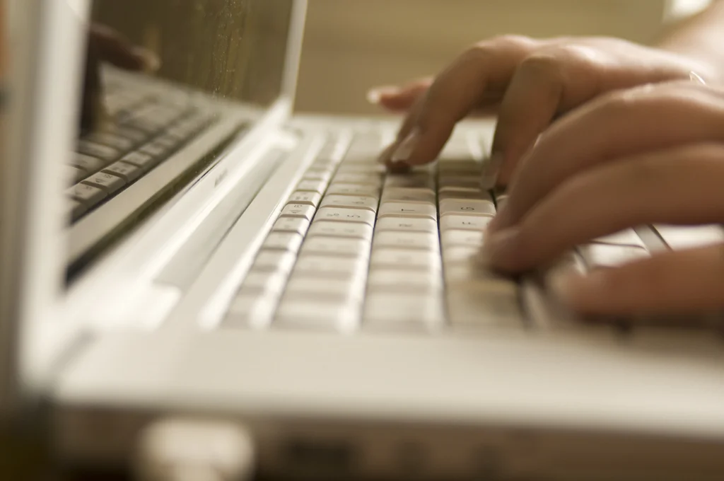 Female hands typing on a laptop keyboard : Free Stock Photo