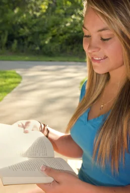Free Stock Photo: A young woman reading a book outdoors