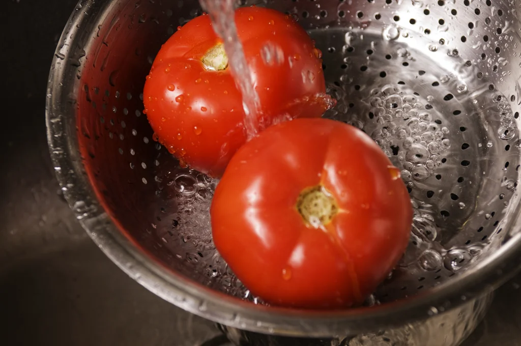 Two fresh tomatoes being washed under running water : Free Stock Photo