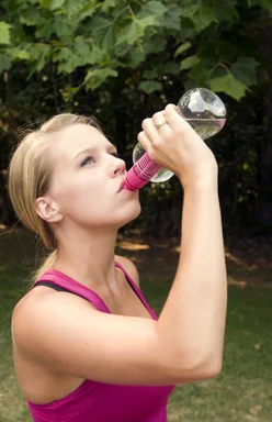 Free Stock Photo: A young woman drinking water during exercise